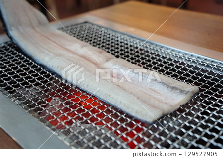 Eel Fillets Grilling on Metal Grid 129527905