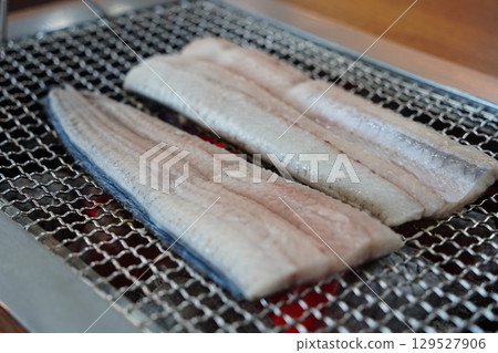 Eel Fillets Grilling on Metal Grid 129527906