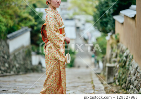A woman in a kimono strolling through the samurai residences A woman in a kimono strolling through the samurai residences 129527963