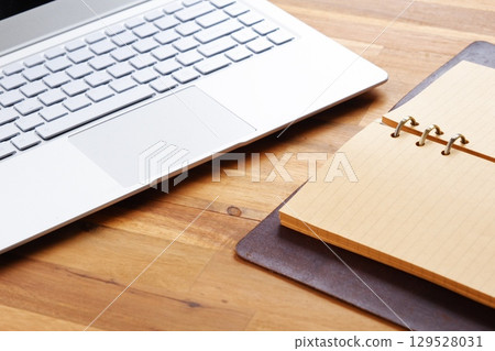 Image of a ring-type system organizer open and doing desk work on a laptop 129528031