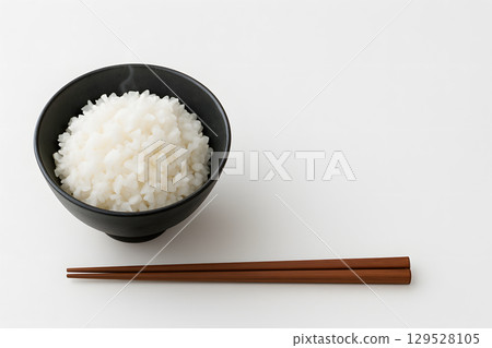 一碗白飯和筷子的極簡主義照片。複製白色背景中的空間 129528105