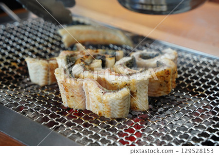 Grilled Eel Slices on Metal Grill 129528153
