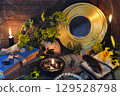 Mystic still life with magic books, tansy flowers, black candles and witchy ritual objects on old table. Occult, esoteric, gothic and wicca concept Mystic still life with magic books, tansy flowers, black candles and witchy ritual objects on old table. Occult, esoteric, gothic and wicca concept 129528798