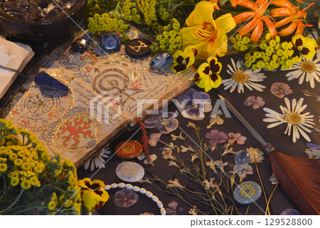 Mystic still life with open magic book of spells, flowers, crystals, black candles and witchy ritual objects on old table. Occult, esoteric, gothic and wicca concept Mystic still life with open magic book of spells, flowers, crystals, black candles and witchy ritual objects on old table. Occult, esoteric, gothic and wicca concept 129528800