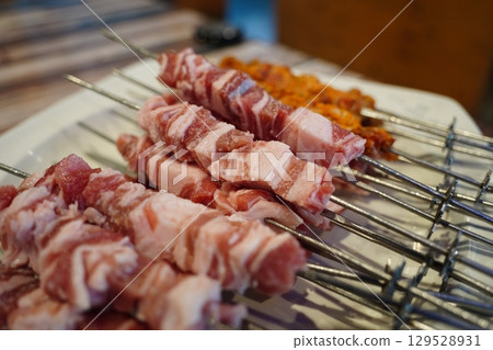 Lamb Skewers on White Plate Ready to Cook 129528931