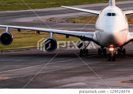 一架大型客機在跑道上行駛的前面 129528974