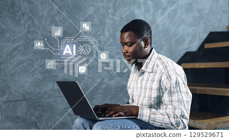 Young man working on laptop focused on artificial intelligence concepts in a modern indoor setting Young man working on laptop focused on artificial intelligence concepts in a modern indoor setting 129529671