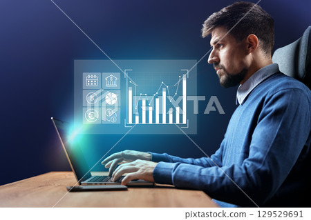 Professional working on financial analysis with data visualization on laptop in a modern office setting at night Professional working on financial analysis with data visualization on laptop in a modern office setting at night 129529691