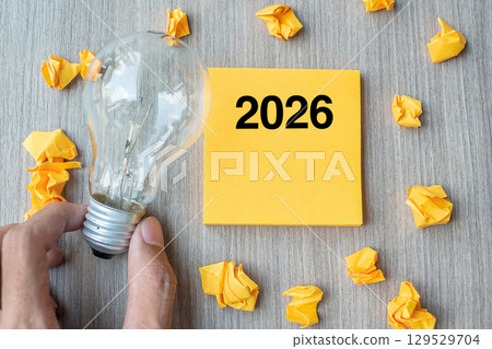 2026 Idea words on yellow note and crumbled paper with Businessman holding lightbulb on wooden table background. New Year New Start Creative, Innovation, Imagination, Resolution and Goal concept 2026 Idea words on yellow note and crumbled paper with Businessman holding lightbulb on wooden table background. New Year New Start Creative, Innovation, Imagination, Resolution and Goal concept 129529704