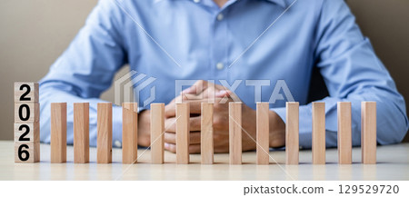 Businessman with  2026 wooden Blocks. Business, Risk Management, Insurance, Resolution, strategy, solution, goal, New Year New You and happy holiday concepts 129529720