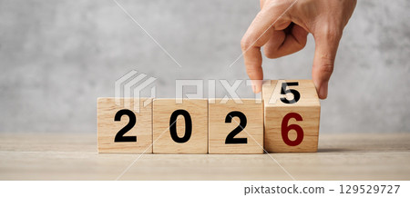 hand flipping block 2025 to 2026  text on table. Resolution, strategy, plan, goal, motivation, reboot, business and New Year holiday concepts 129529727