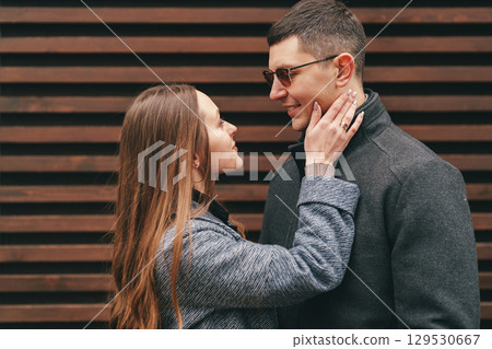 Young couple sharing a romantic moment outdoors in a city setting during a sunny day 129530667