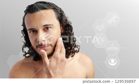 Man applying skincare product in a modern setting with health and beauty elements in the background 129530897
