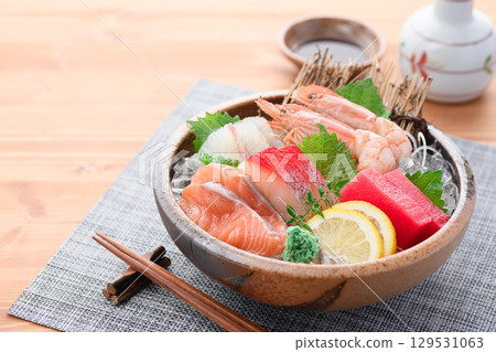 A luxurious sashimi platter with plenty of fresh seafood and sake. High-quality food photos perfect for banquets and menus. 129531063