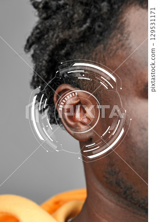 Futuristic ear design integrated with technology on a person's head in a modern setting 129531171
