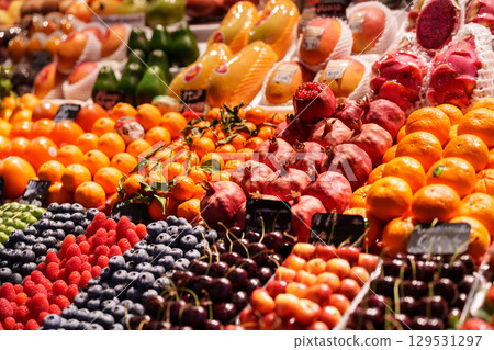 Fresh fruits displayed at a vibrant market stall attracting shoppers and visitors Fresh fruits displayed at a vibrant market stall attracting shoppers and visitors 129531297