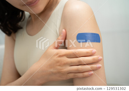 HPV, Human papillomavirus, Asian young woman receiving vaccine with blue bandage. 129531302