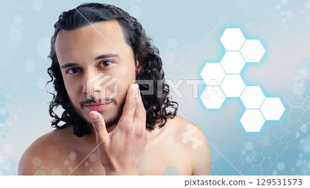Man with curly hair demonstrating skincare routine against a light blue background with abstract shapes 129531573