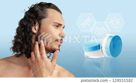 Man applying skin care product with blue packaging in a clean, modern setting highlighting facial care 129531582