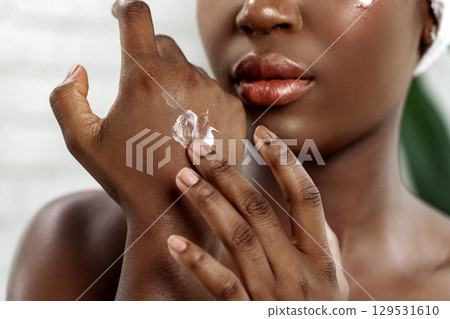 Skincare routine with moisturizer application in a bright indoor setting during the day 129531610