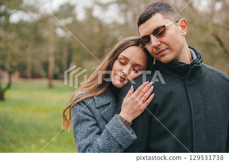 Couple enjoying a tender moment in a tranquil park setting during springtime 129531738
