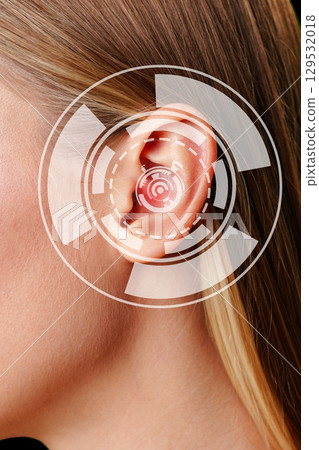 Close-up view of a woman's ear with digital sound wave representation in a modern setting during daylight hours 129532018