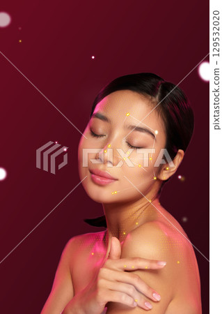 Portrait of a woman with glowing skin and artistic facial design against a rich red background showcasing beauty and creativity Portrait of a woman with glowing skin and artistic facial design against a rich red background showcasing beauty and creativity 129532020