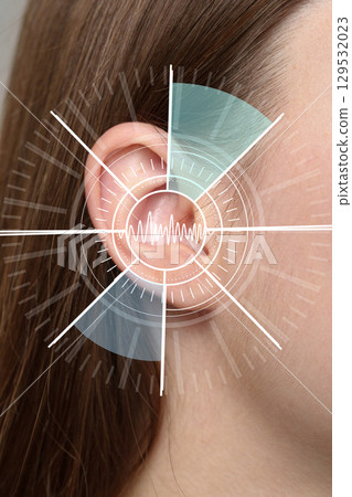 Detailed look at human ear with sound wave illustration in a clinical setting 129532023