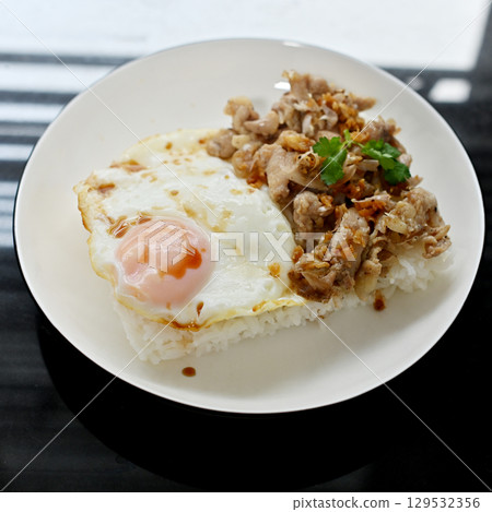 Thai basil chicken with fried egg on a white plate Thai basil chicken with fried egg on a white plate 129532356