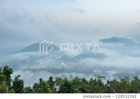 The city and mountains are covered in fog. The city and mountains are covered in fog. 129532391