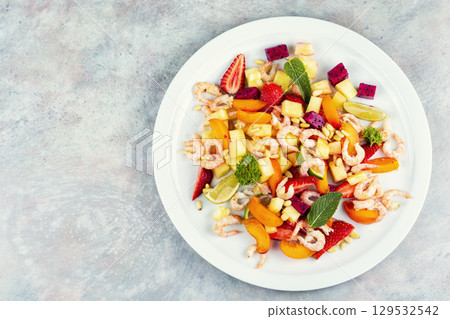 Plate of shrimp fruits salad, food photography. 129532542