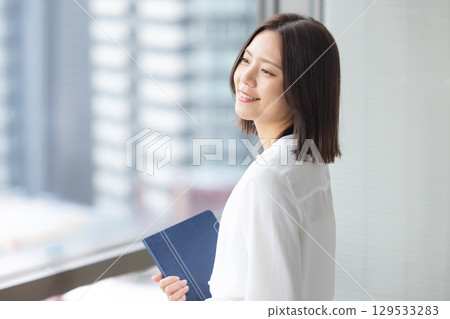 站在窗戶旁邊的女商人 129533283