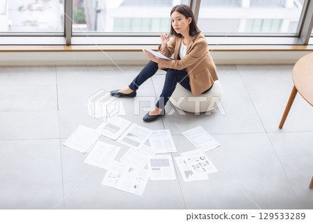 女商人在地板上傳播文件 129533289