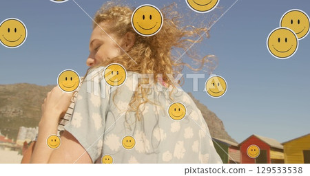 Image of emoji icons over happy caucasian couple embracing at beach Image of emoji icons over happy caucasian couple embracing at beach 129533538