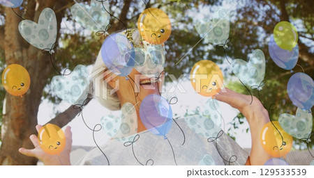 Image of balloons icons over happy senior caucasian woman 129533539