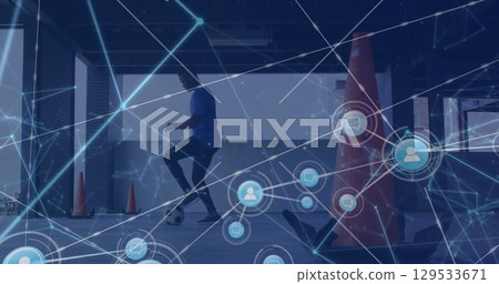 Network of digital icons against african american male soccer player practicing 129533671