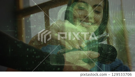 Image of digital padlock over hands of caucasian woman using payment terminal and smartphone 129533706