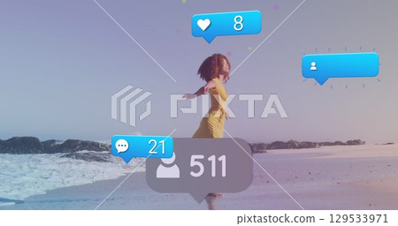 Image of social media icons and numbers on banners over woman running on beach 129533971