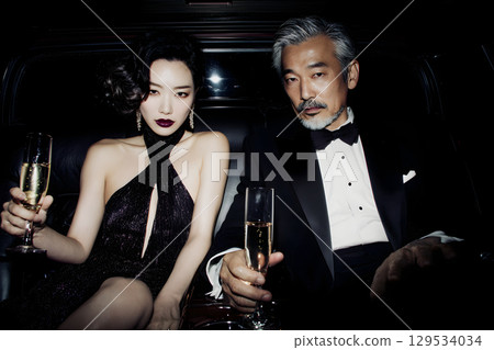 一對成熟夫婦在豪華轎車裡享用香檳的奢華夜生活 一對成熟夫婦在豪華轎車裡享用香檳的奢華夜生活 129534034