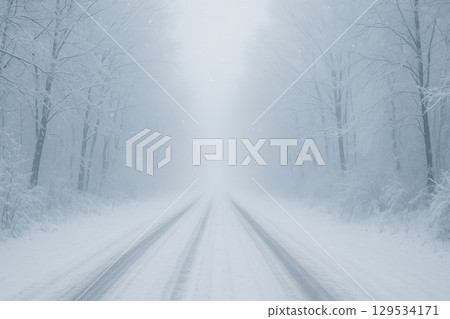 A Tranquil Winter's Path: A Snow-Covered Road Surrounded by Frosty Trees 129534171