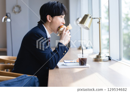 Man stuffing his face with a hamburger Man stuffing his face with a hamburger 129534682