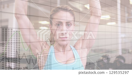 Image of statistical data processing over caucasian fit woman working out with dumbbells at gym Image of statistical data processing over caucasian fit woman working out with dumbbells at gym 129535297