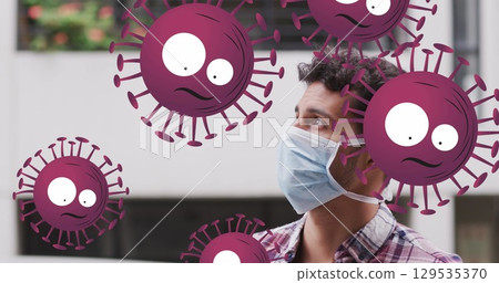 Image of falling covid 19 cells over men wearing face mask 129535370