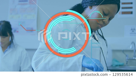 Image of round scanner over african american female scientist working at laboratory 129535614