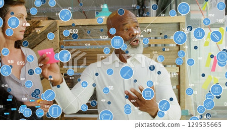Image of data processing over diverse business people taking notes Image of data processing over diverse business people taking notes 129535665