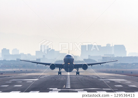 Front of a passenger plane taking off from the runway 129536413