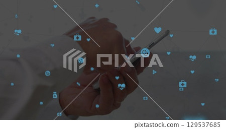 Image of medical icons over hands using smartphone 129537685