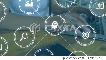Image of falling education icons over person using laptop 129537746
