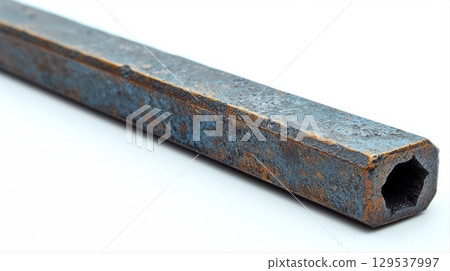 hexagonal steel bar rusty surface rests on white background. bar shows signs of aging blue and orange patina showcasing its industrial use over time. 129537997