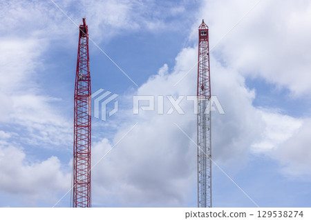 Crawler crane on blue sky white clouds background, Real estate industry. Red crawler crane use reel lift up equipment in construction site. Crane for rent. Crane dealership for construction business. Crawler crane on blue sky white clouds background, Real estate industry. Red crawler crane use reel lift up equipment in construction site. Crane for rent. Crane dealership for construction business. 129538274